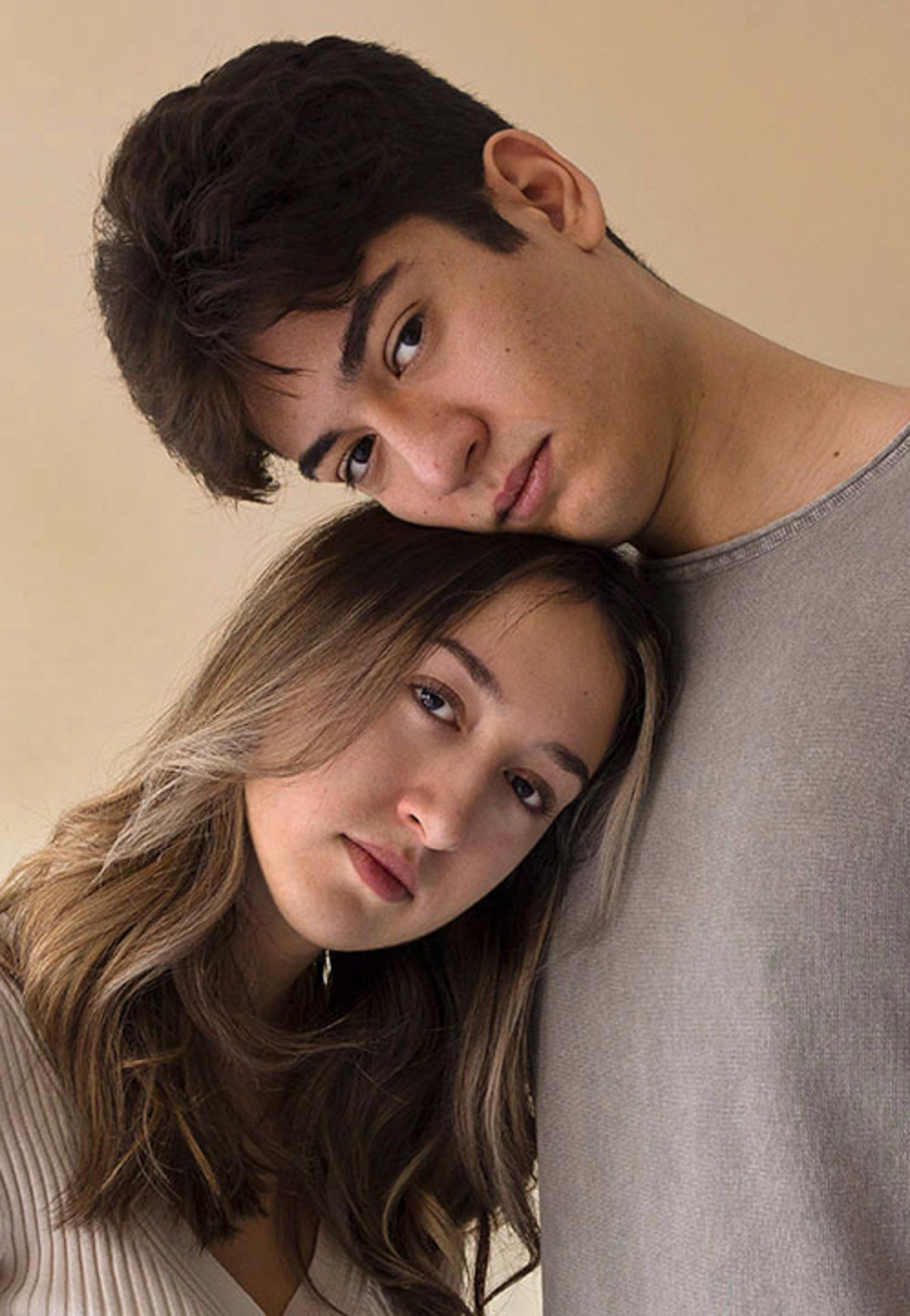 Amelia Sopta This photo consists of a self-portrait of a woman and a man. The two are wearing a beige and gray t-shirt. The woman’s head is resting on the man’s chest and his head on top of hers.