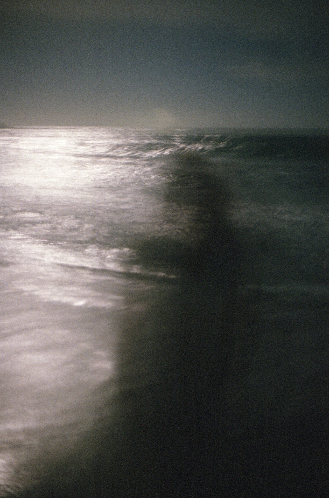 Eden’s shadow is very blurred against the background of ocean waves. Her figure is slightly distorted and becomes almost see through.