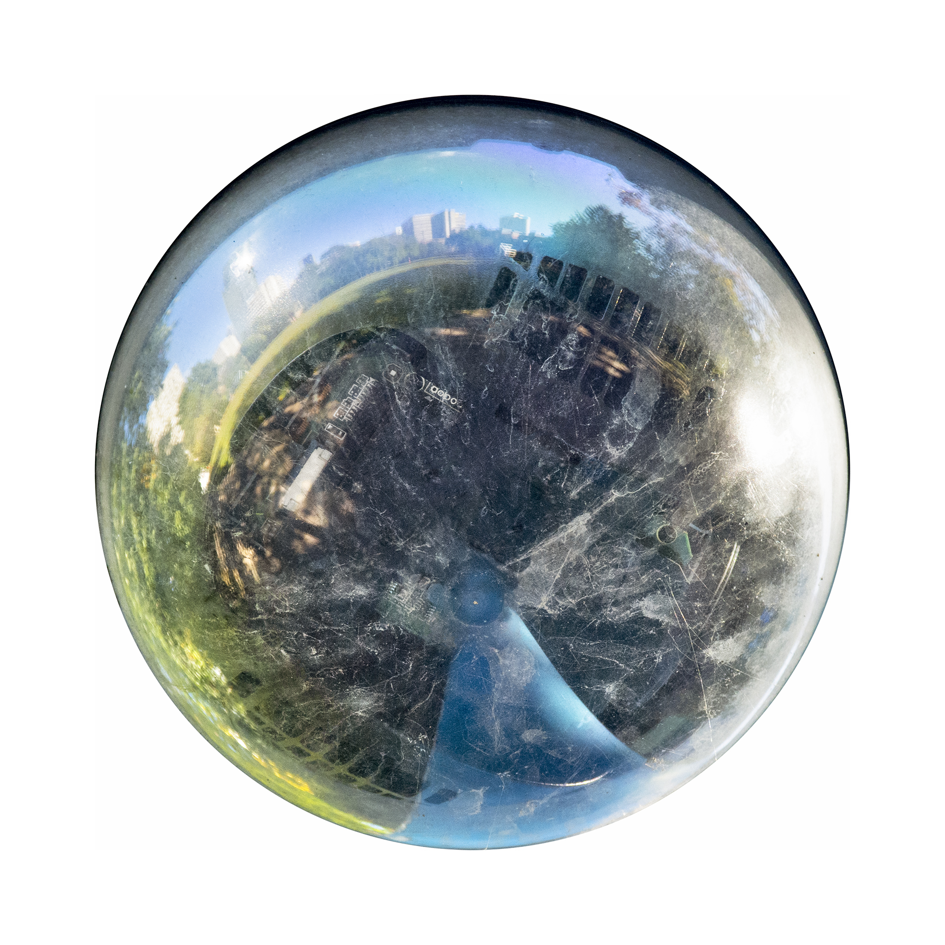 Distorted reflection of urban cityscape and park in a circular security camera lens.