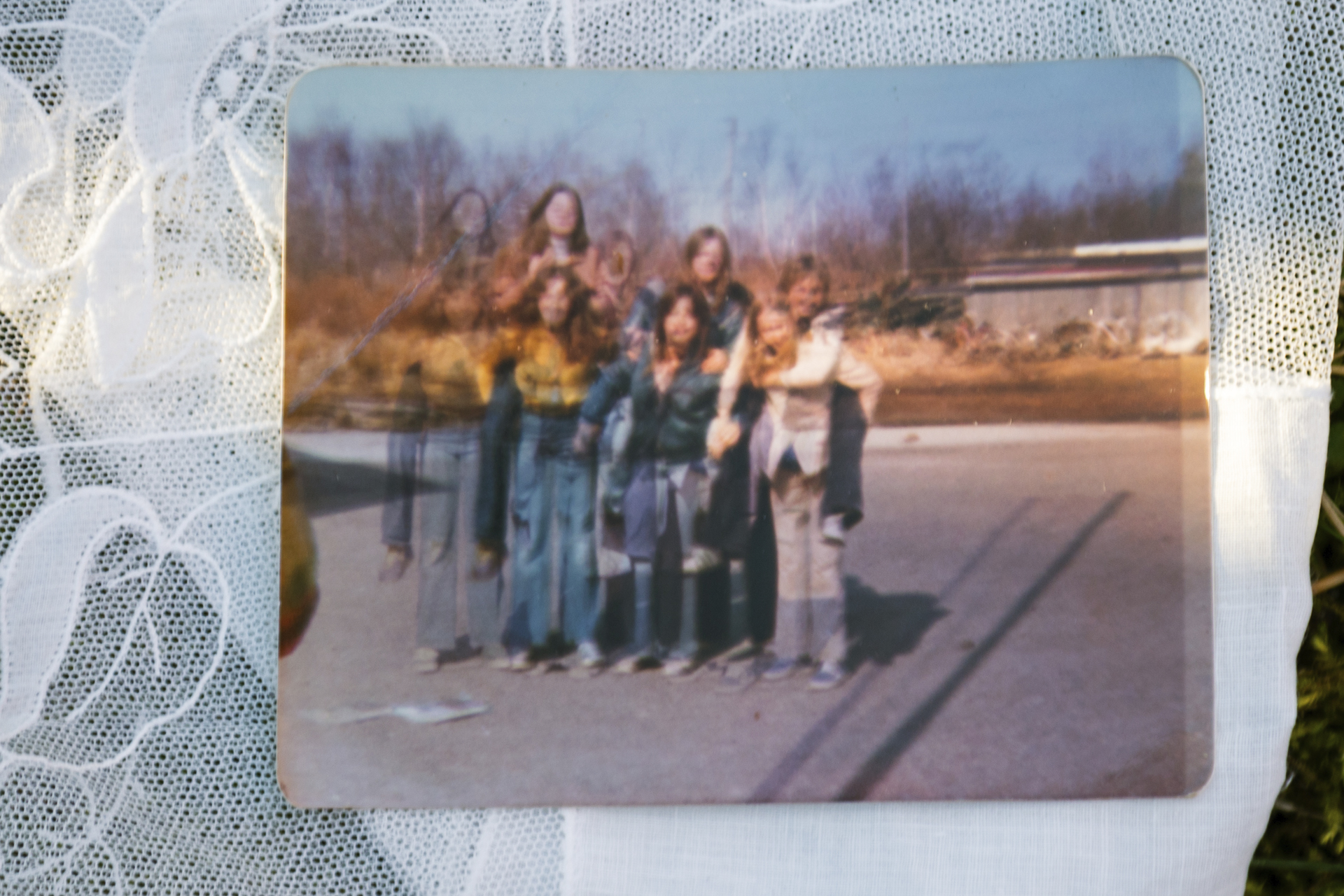 Let me in: a double exposed picture of a group of girls which is sitting on top of a lacy floral doily.