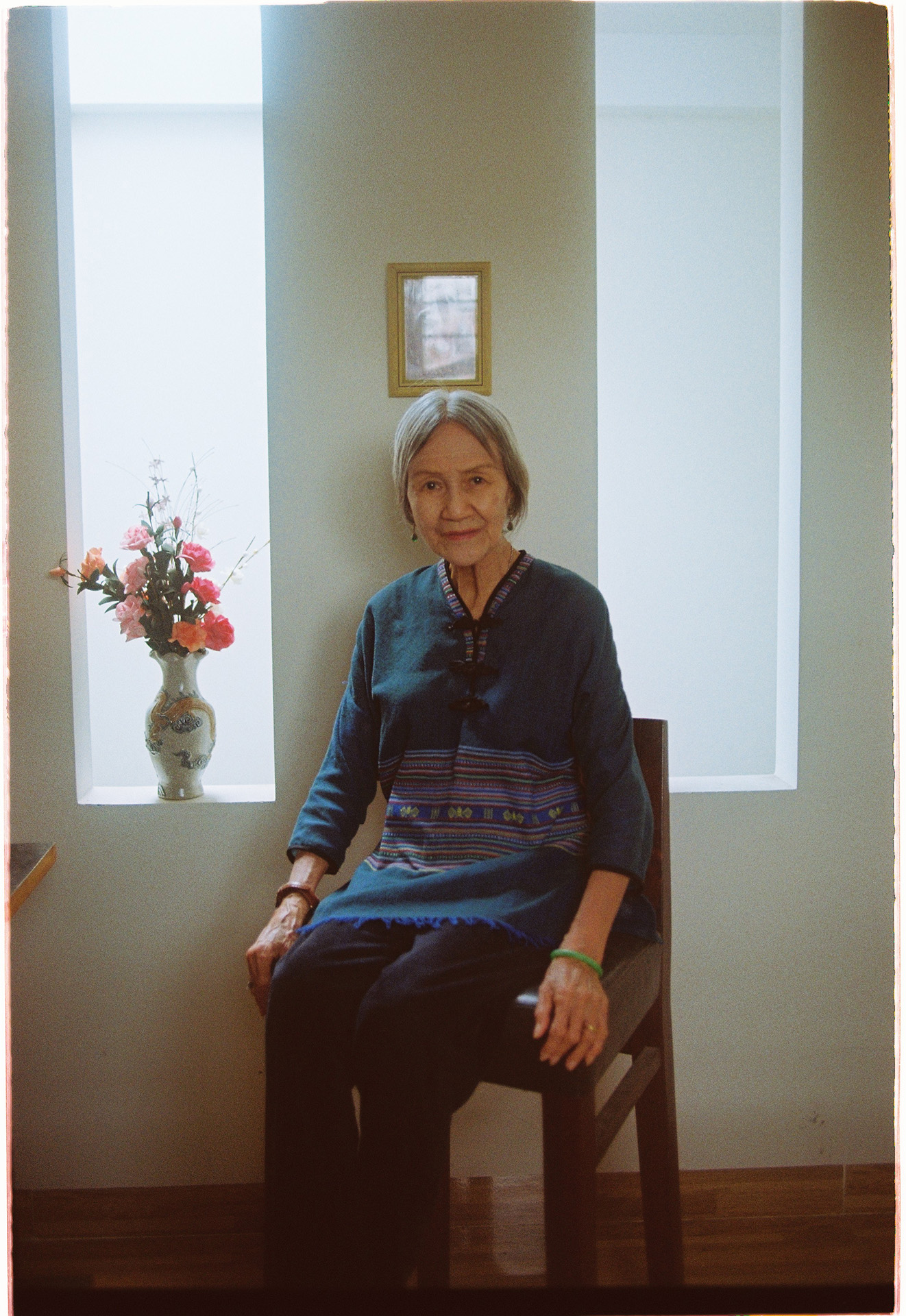 Hoa An elder Vietnamese woman sits and poses for the photograph by her alter.