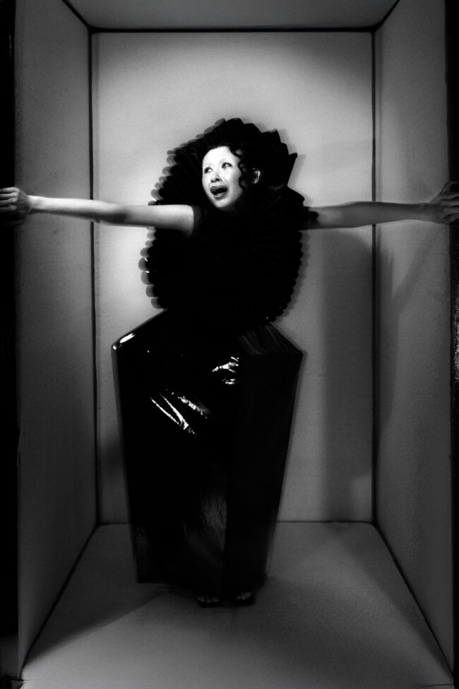 A full body image of a model yelling inside a confined space.